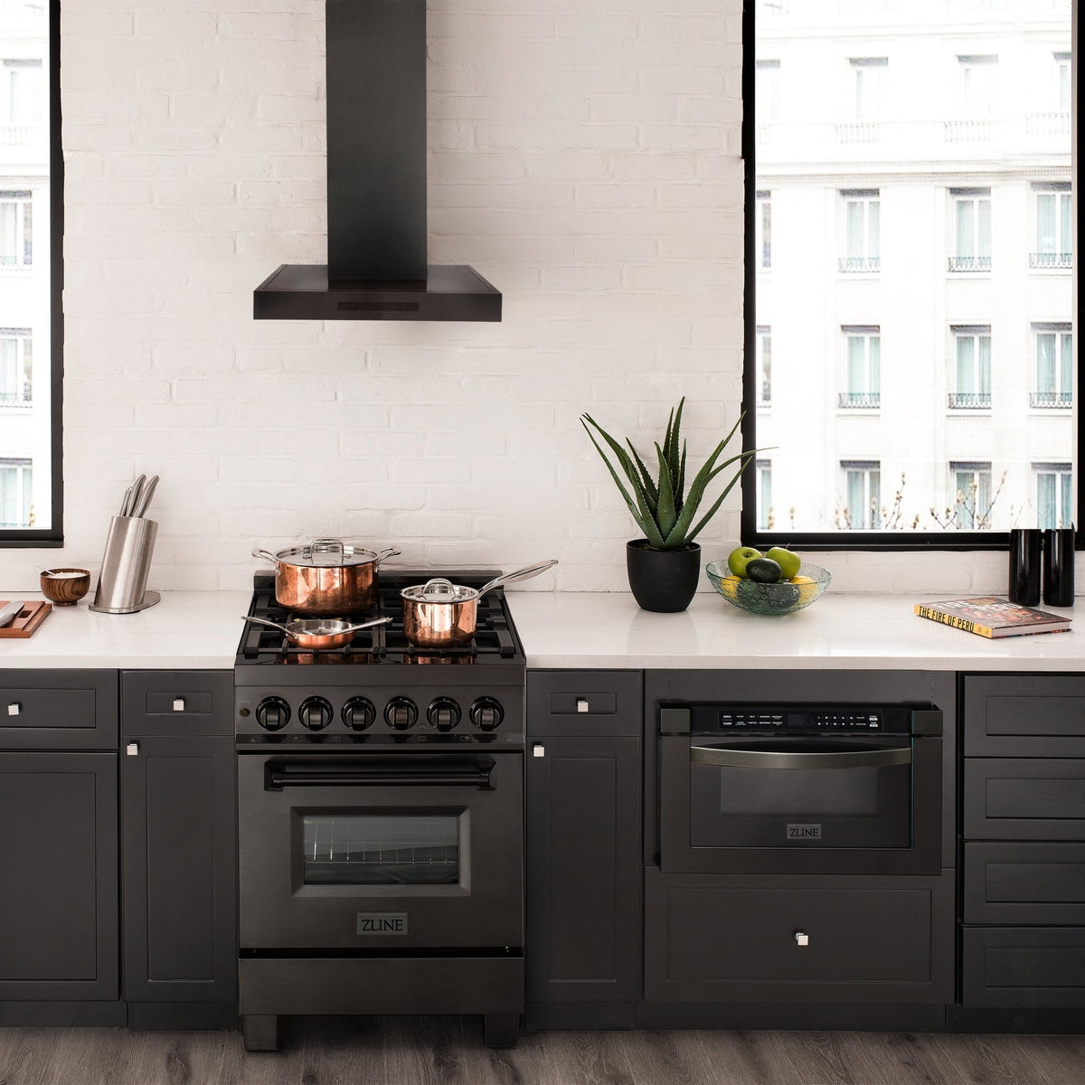 Black stainless steel wall-mount range hood installed above a black kitchen cooktop