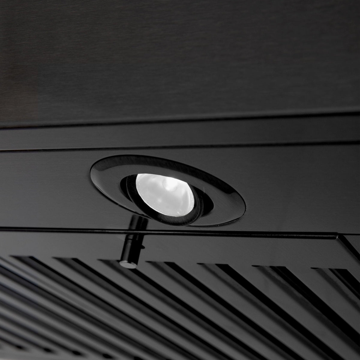 Close-up of black stainless steel hood filter area with round light and slotted vents