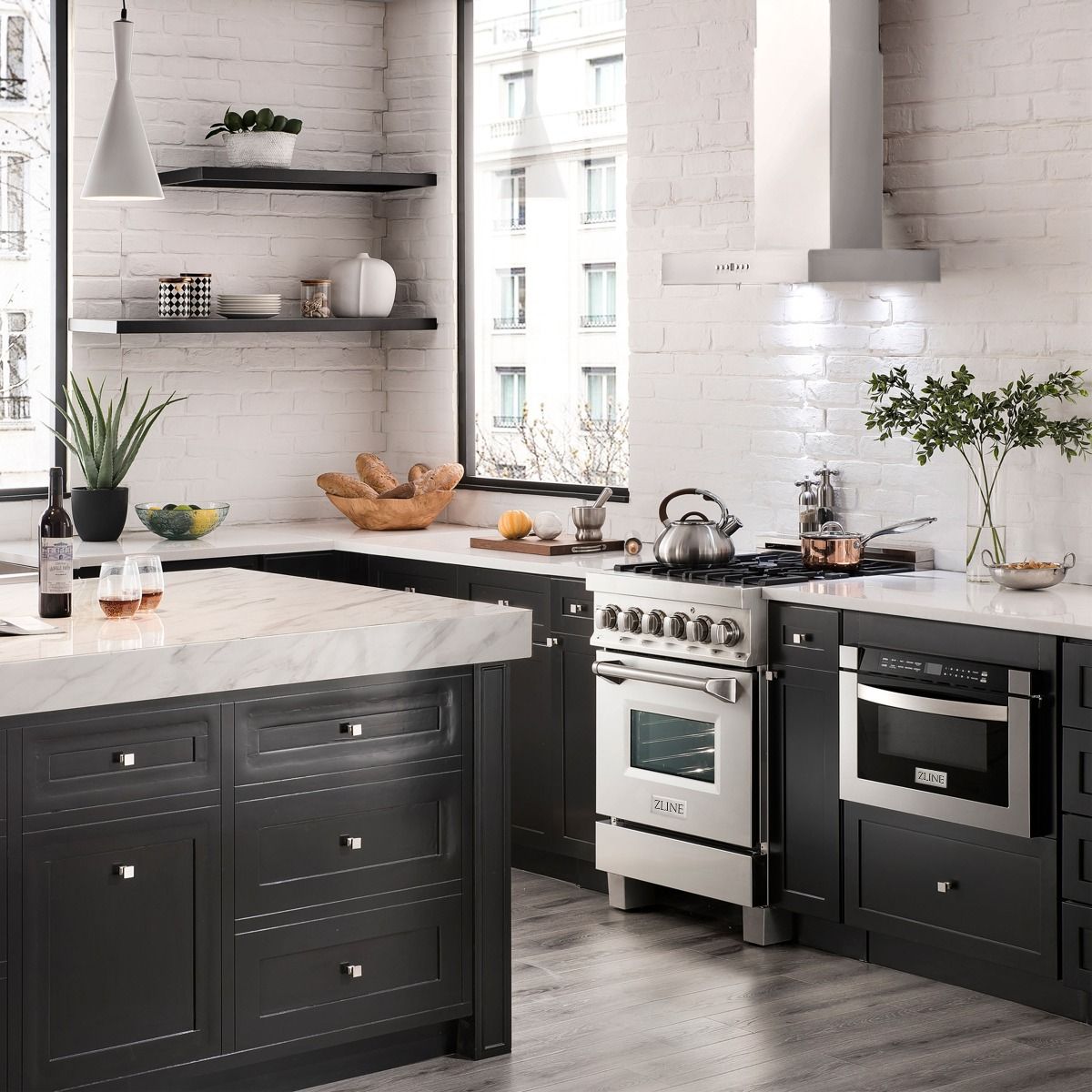 Stainless steel range hood above a multi-burner cooktop with chimney-style venting