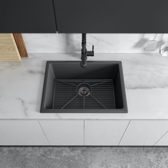 Charcoal single-bowl kitchen sink with wire rack at bottom and black faucet