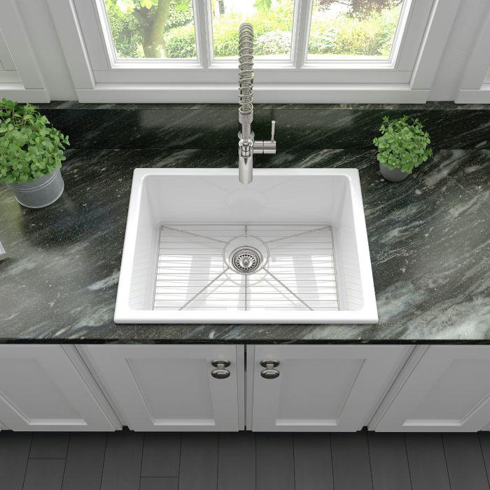 Top view of white single-bowl fireclay kitchen sink with stainless drain strainer