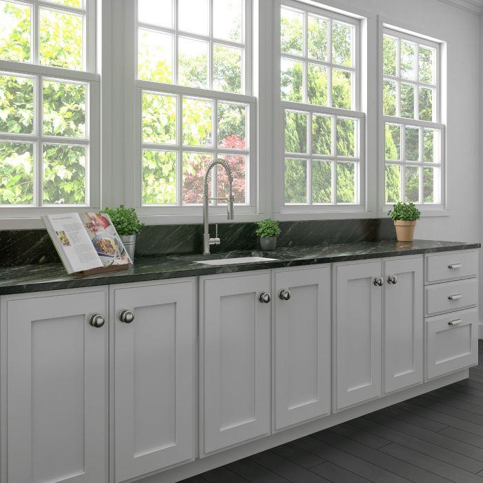 White single-bowl fireclay kitchen sink with deck-mounted faucet