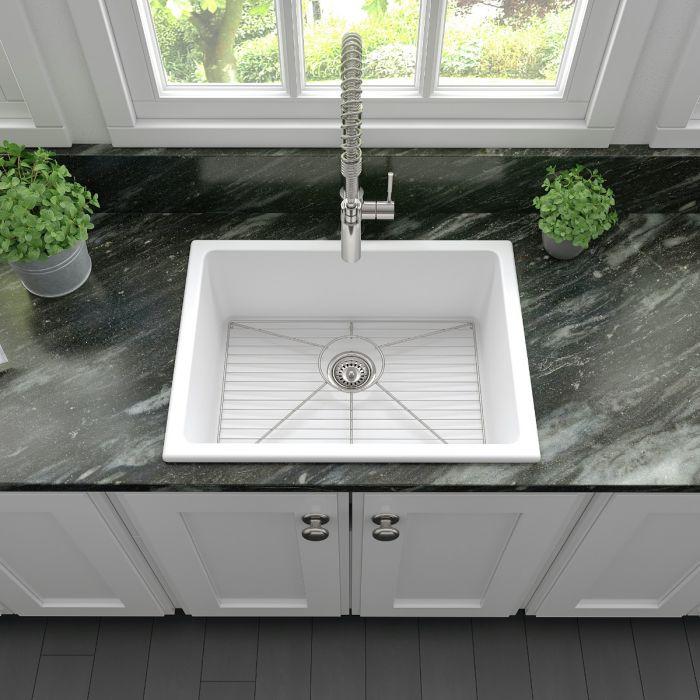 White single-bowl sink with metal faucet and round drain strainer on countertop