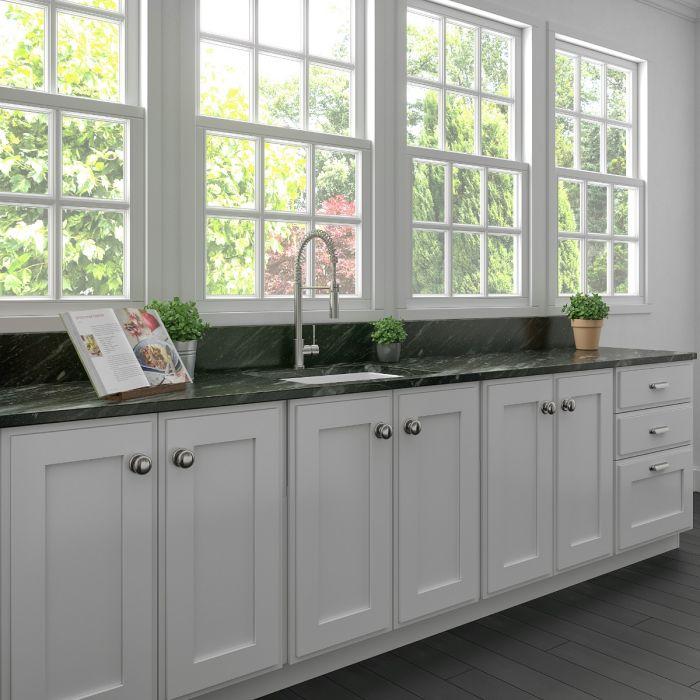 White matte single-bowl fireclay kitchen sink with faucet and rear-set drain