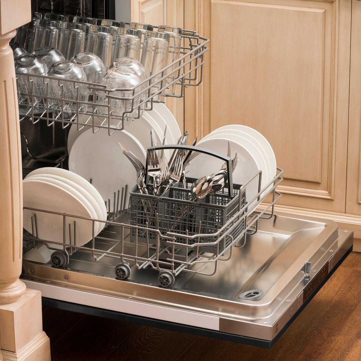 Open dishwasher with metal racks, silver interior tub, and loading baskets