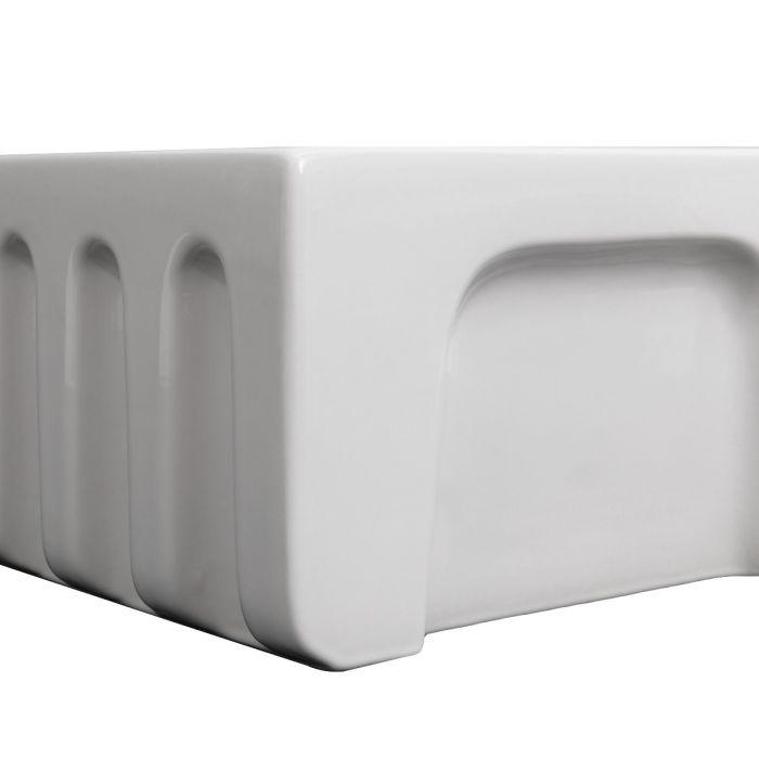 Close view of white apron-front single-bowl sink with rear corner drain area