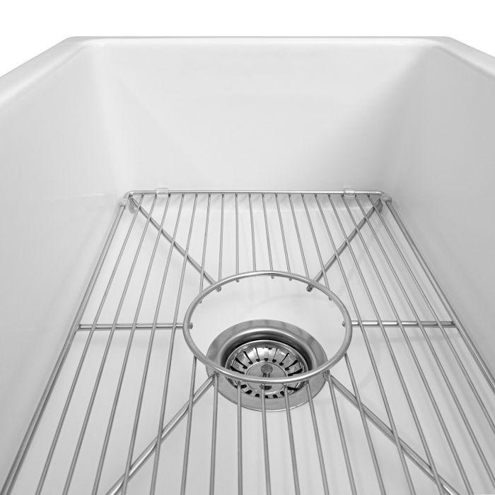 White fireclay sink basin with chrome bottom grid and drain opening