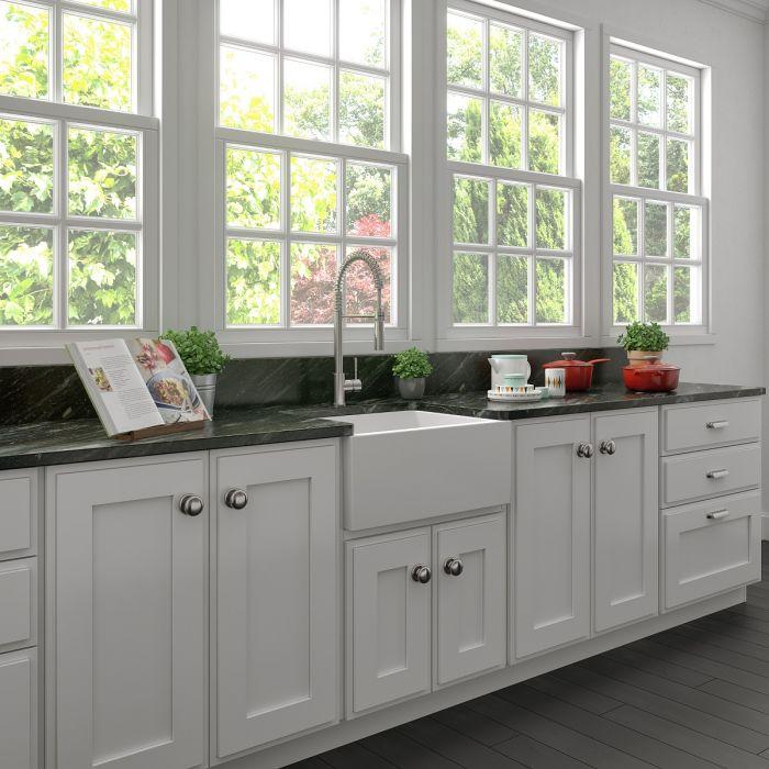 White apron-front farmhouse kitchen sink with built-in faucet and single basin