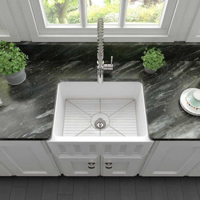 White matte single-bowl sink showing bottom grid and centered drain with faucet