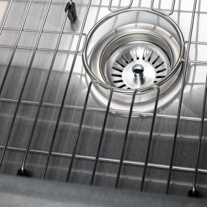 Single-bowl sink interior with metal bottom grid and circular drain opening