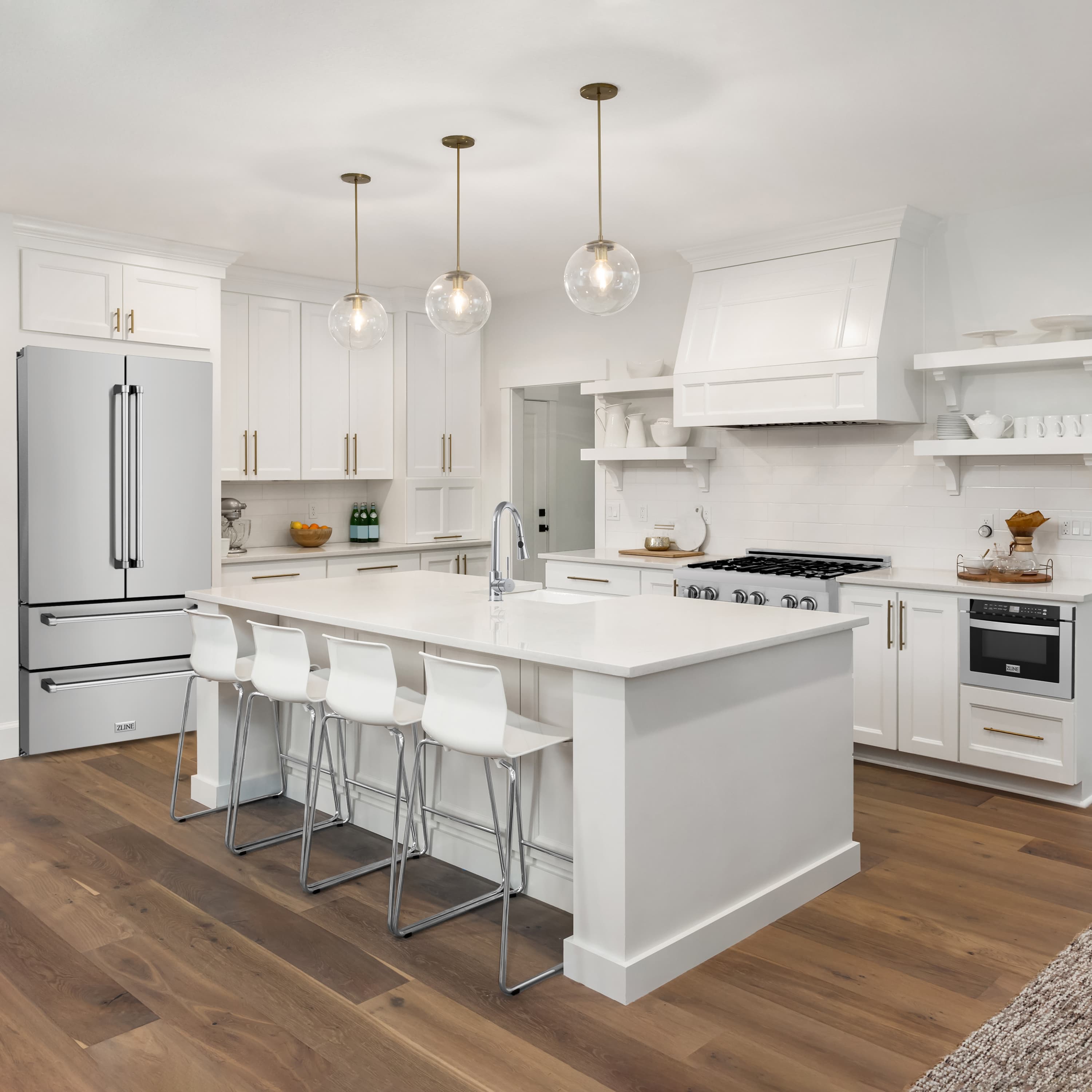 Stainless kitchen appliance package with refrigerator, range, and range hood