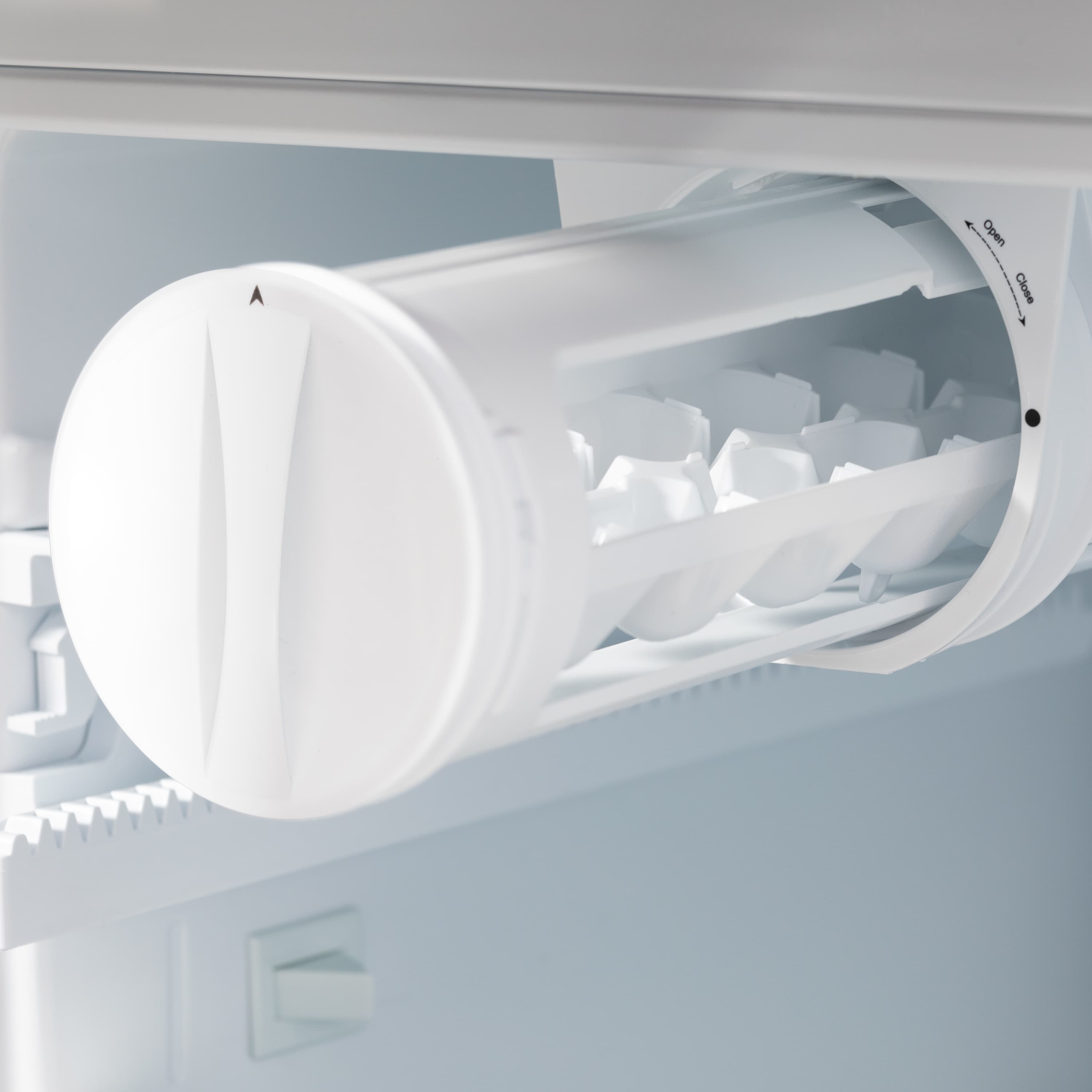 Refrigerator ice maker chute with circular dispenser and visible ice cubes