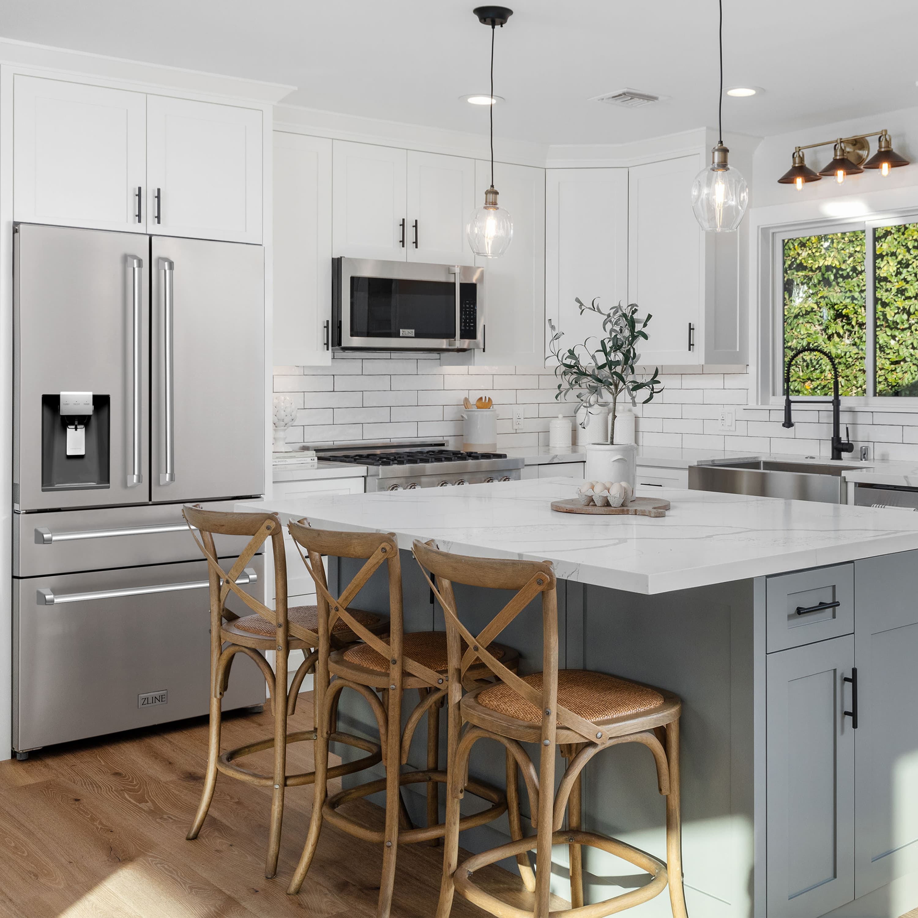 Stainless steel kitchen appliances with range hood and microwave above the cooktop