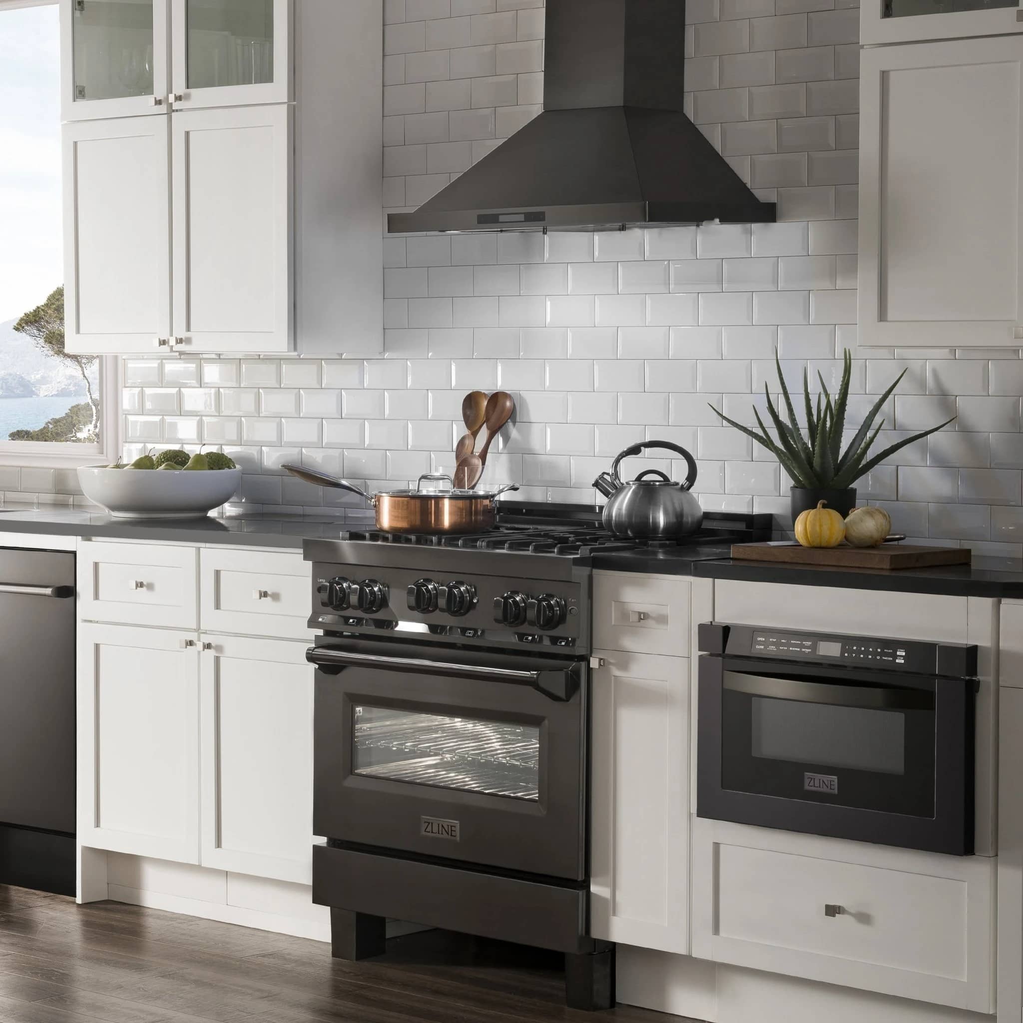 Black dual fuel range with oven door and wall-mounted stainless steel range hood