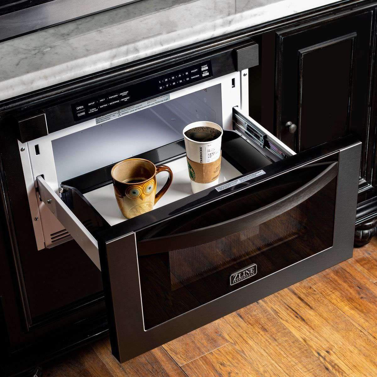 Open black stainless steel microwave drawer with interior light and cookware