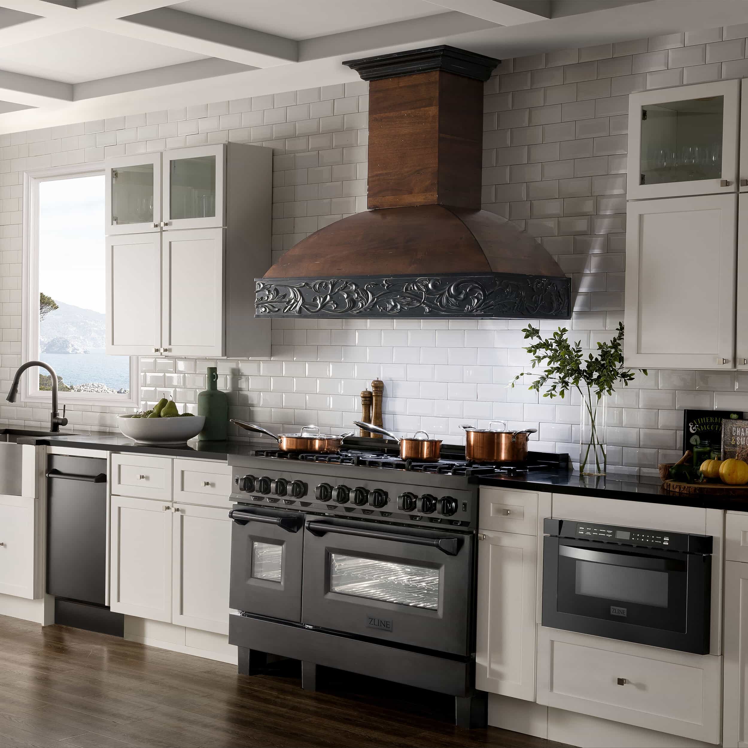 Stainless and black dual fuel range with chimney hood in kitchen