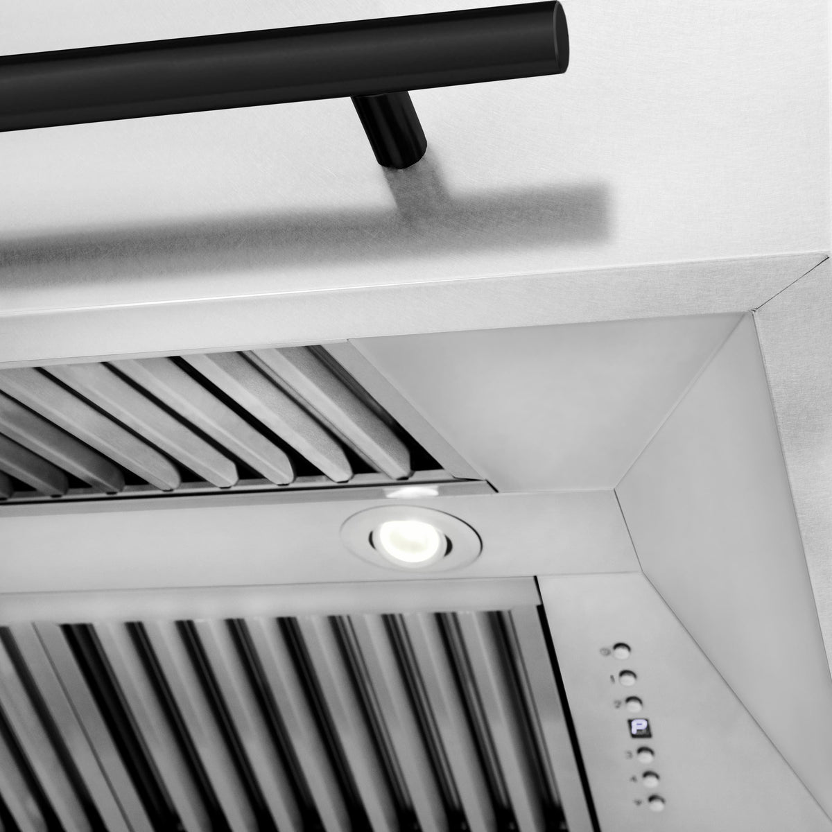 Interior view of wall mount range hood: satin stainless baffle vents and light