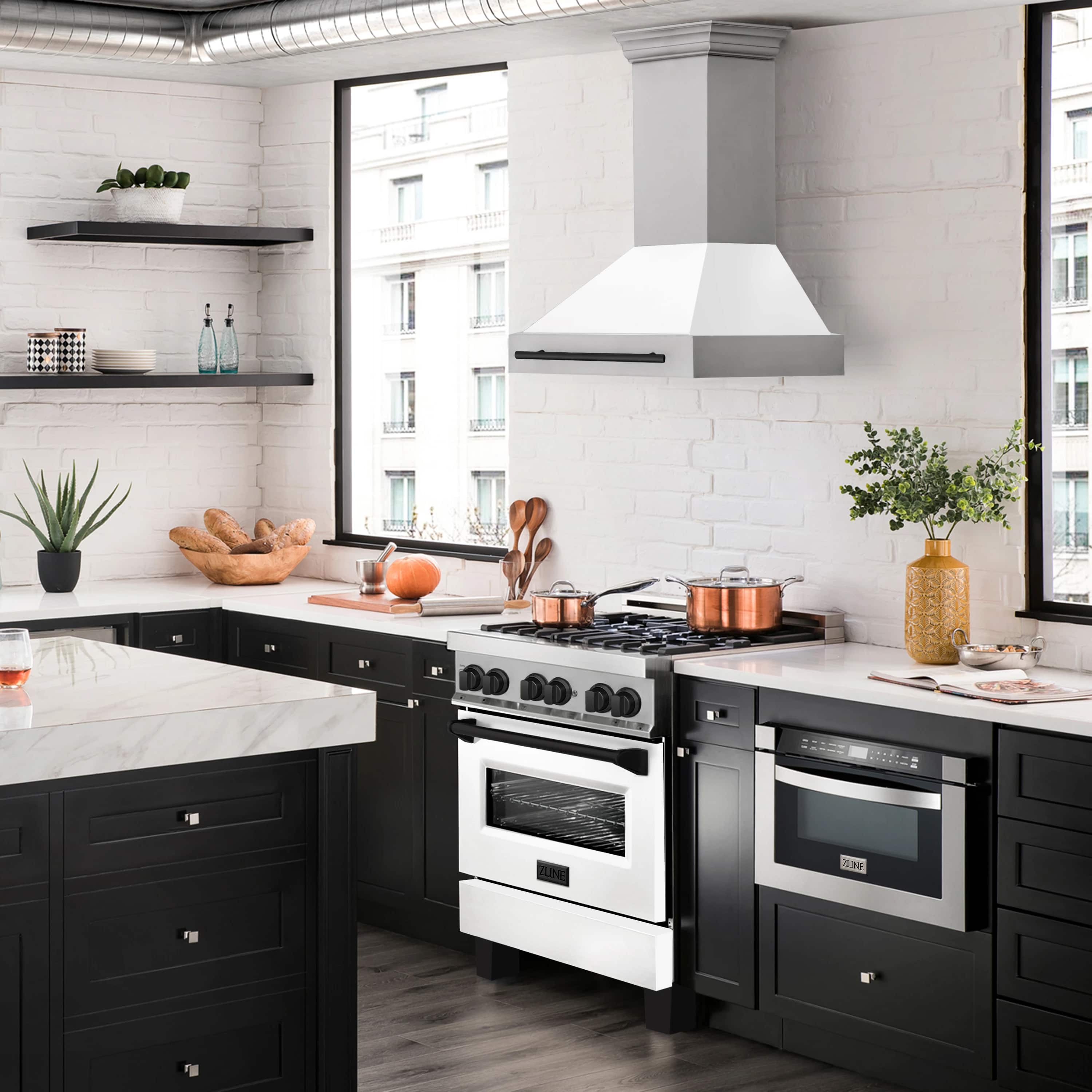 White matte wall mount range hood with black handle above a stainless stove area.