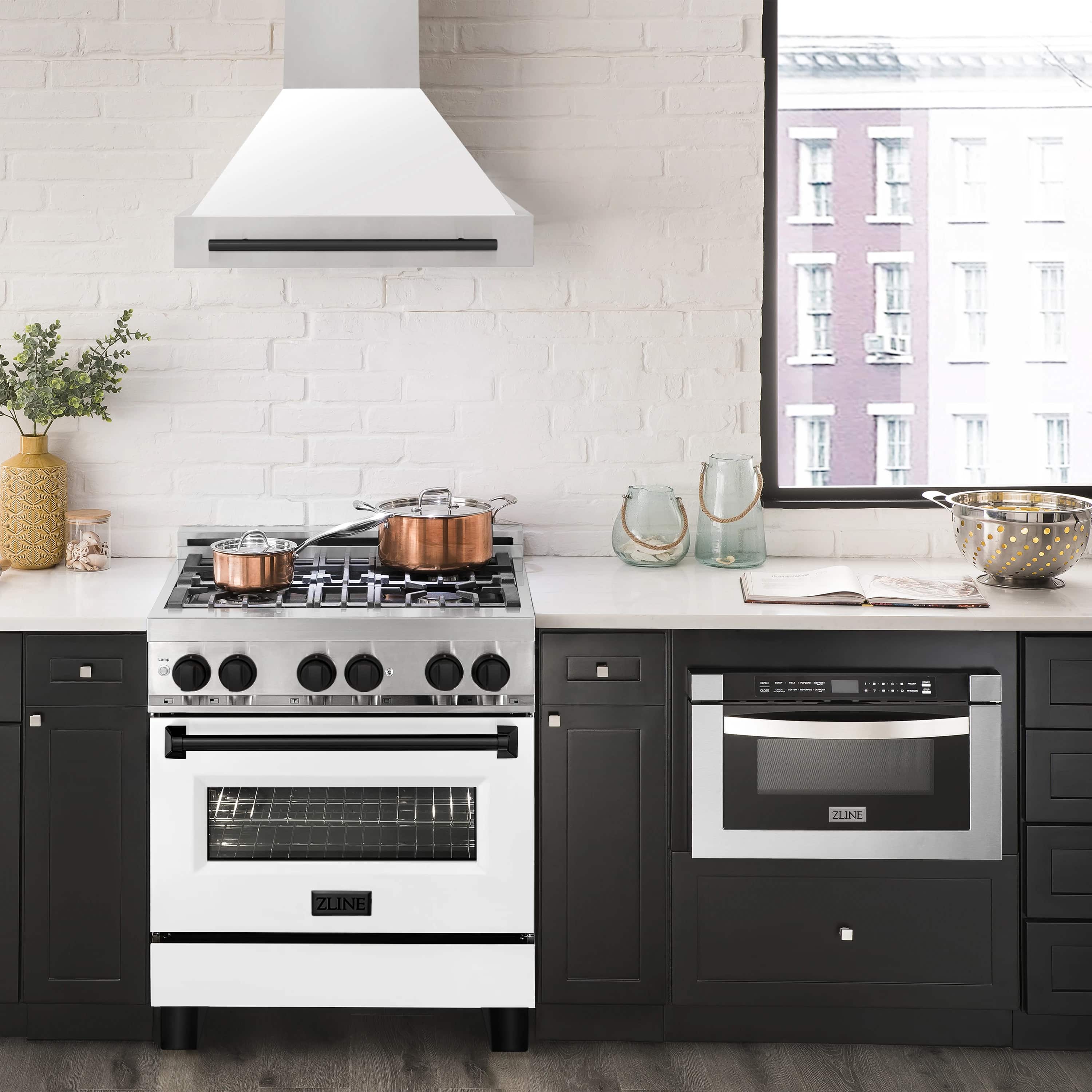 Stainless and white wall mount range hood with matte black handle in modern kitchen.
