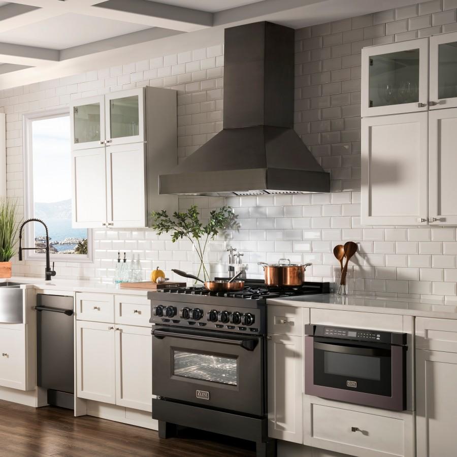 Black wall mount range hood above a kitchen range with stainless and dark cabinetry