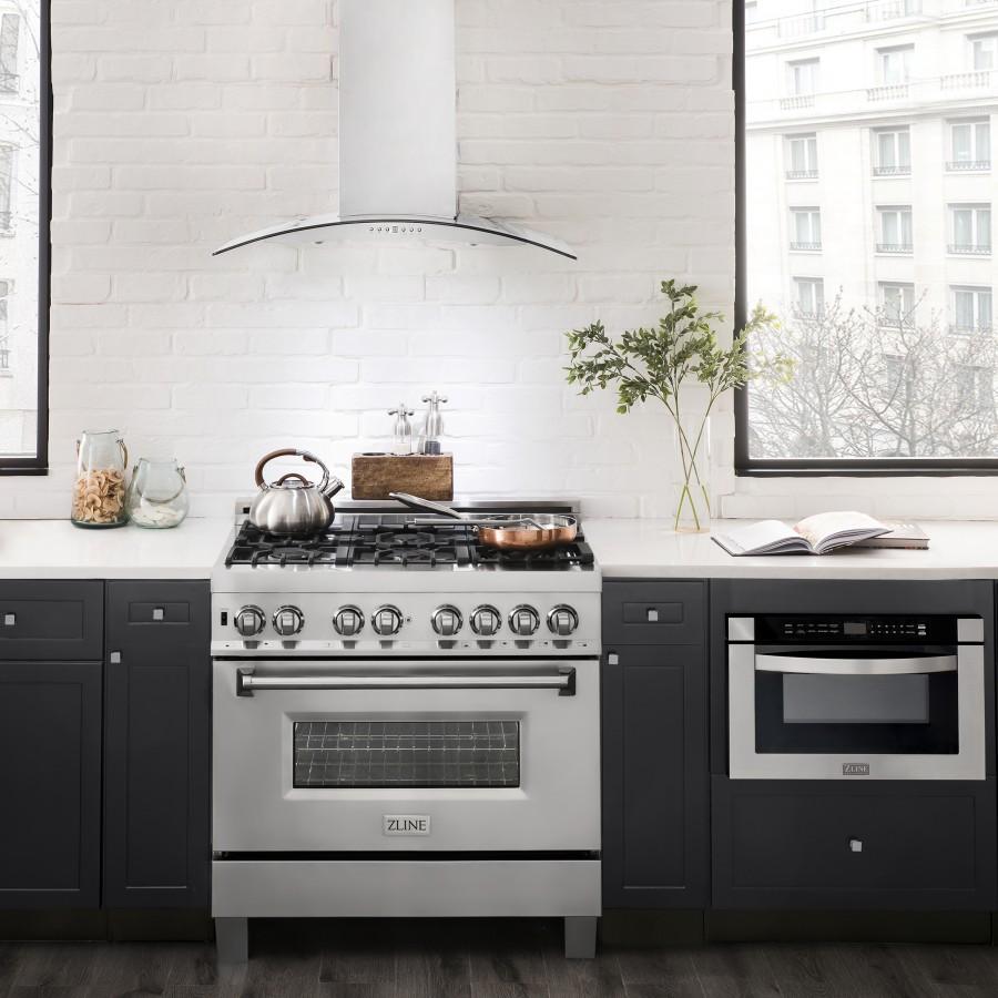 Stainless steel wall range hood with arched glass canopy over gas cooktop.