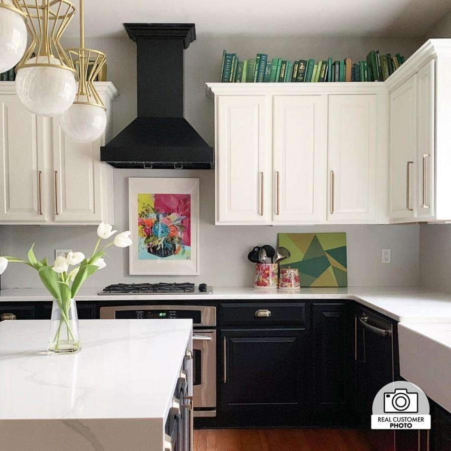 Black chimney range hood over cooktop, stainless baffle filter and integrated lights
