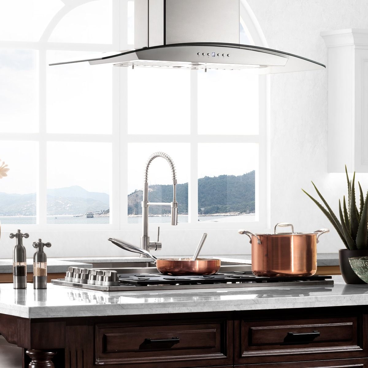 Black gas cooktop with four burners and cast-iron grates beneath a range hood