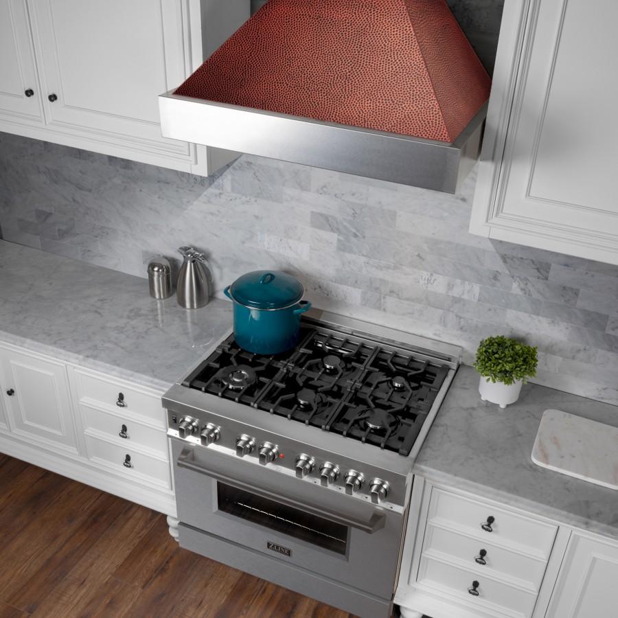 Close view of range hood over cooktop; stainless chimney with copper hand-hammered top