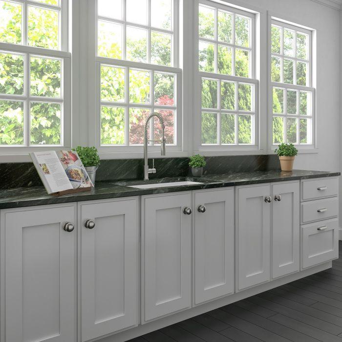White fireclay single-bowl kitchen sink installed with faucet and basin drain area