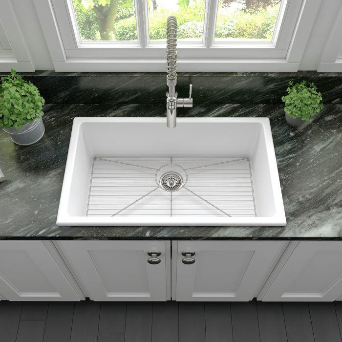 Matte white single-bowl kitchen sink with stainless drain and bottom rack