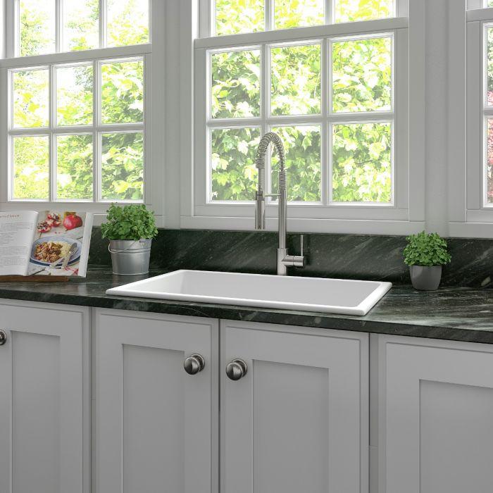 Matte white fireclay single-bowl kitchen sink with faucet and rectangular basin