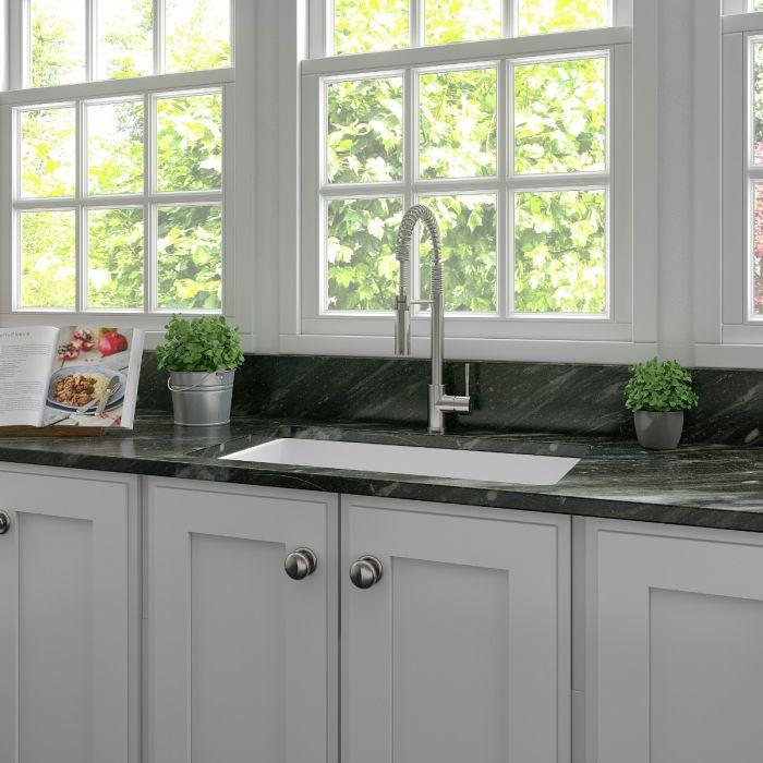 Installed single-bowl white matte fireclay kitchen sink with faucet