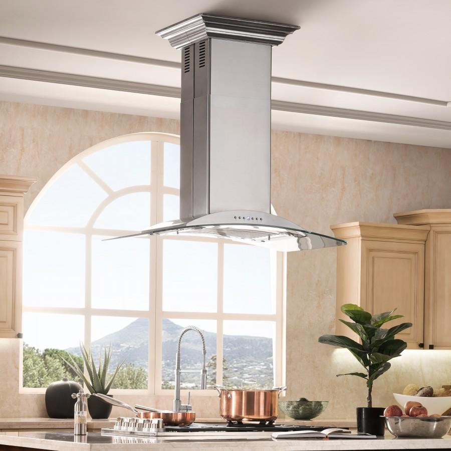 Island range hood with tall chimney above stove, glass splash shield, and control panel
