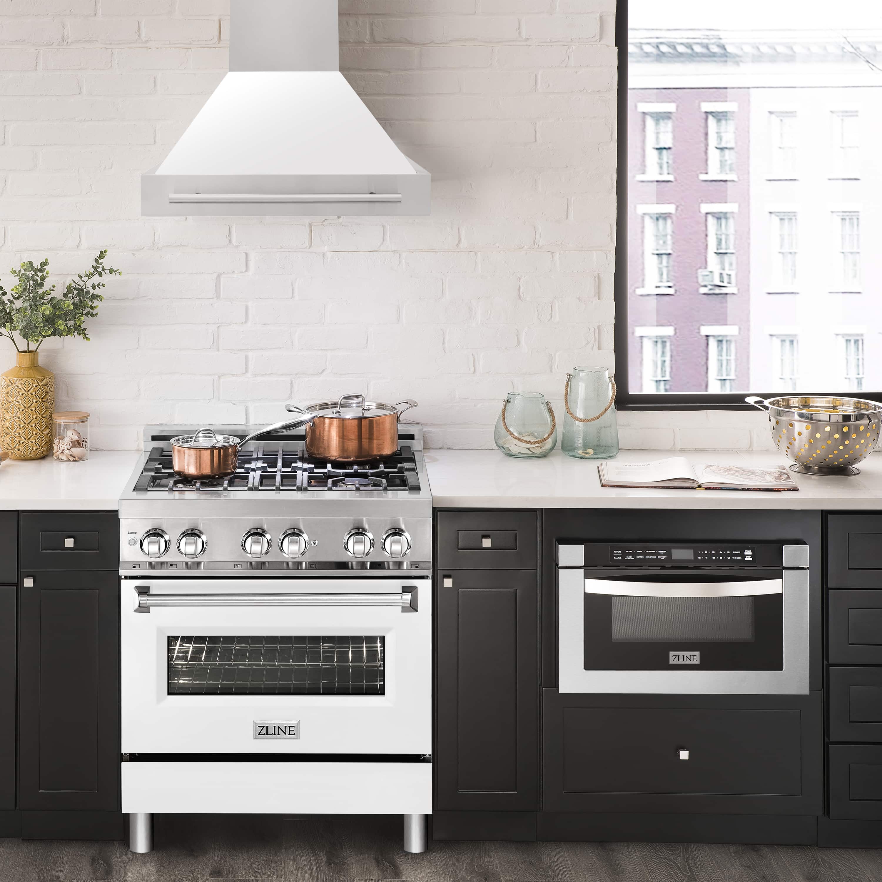 White wall mount range hood centered over a stove with stainless controls