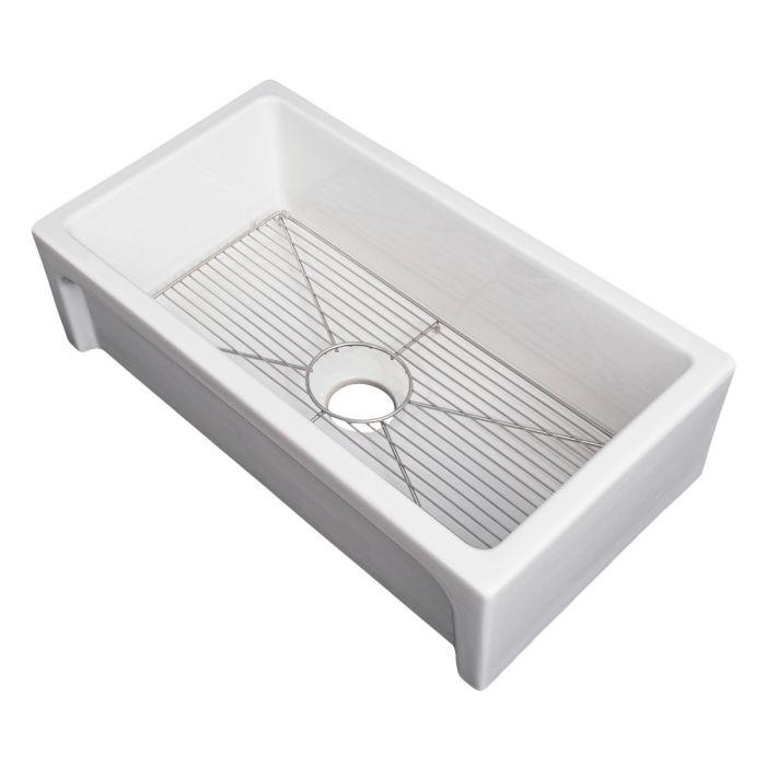White single-bowl fireclay sink with wire bottom grid and drain strainer