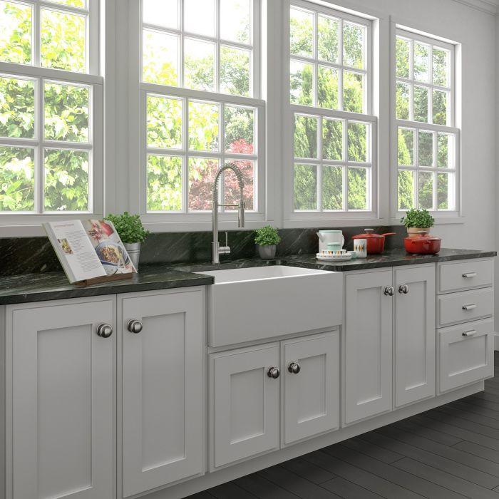 Apron-front single-bowl sink in white matte finish installed in a kitchen countertop