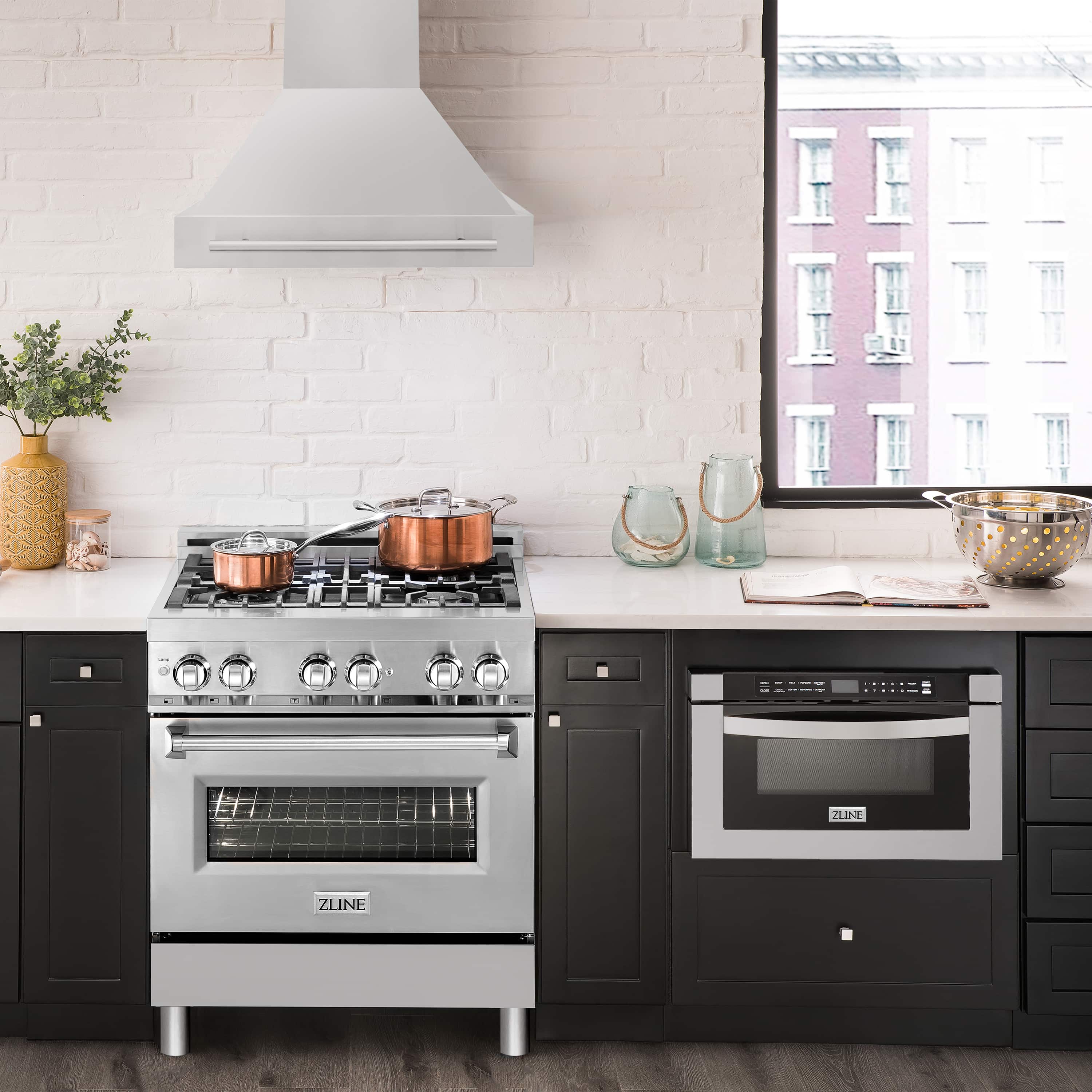 Stainless steel wall-mount range hood over cooktop with chimney and vent