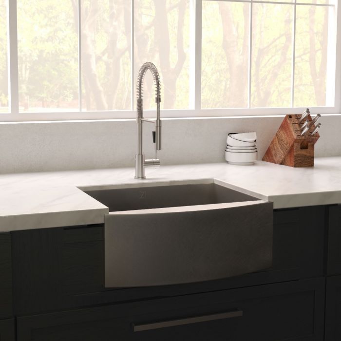 Installed single-basin stainless apron sink on dark kitchen cabinetry