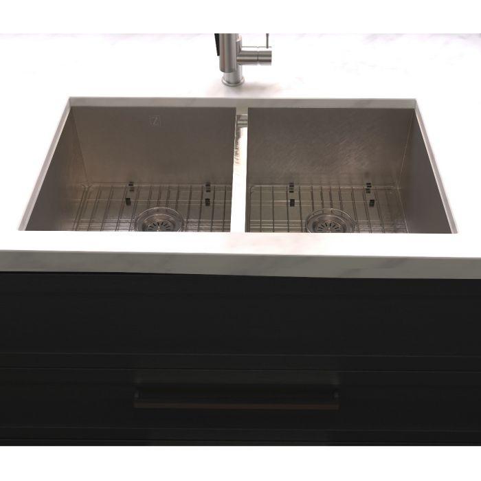 Stainless steel double-bowl undermount sink close-up from front edge with drain openings visible
