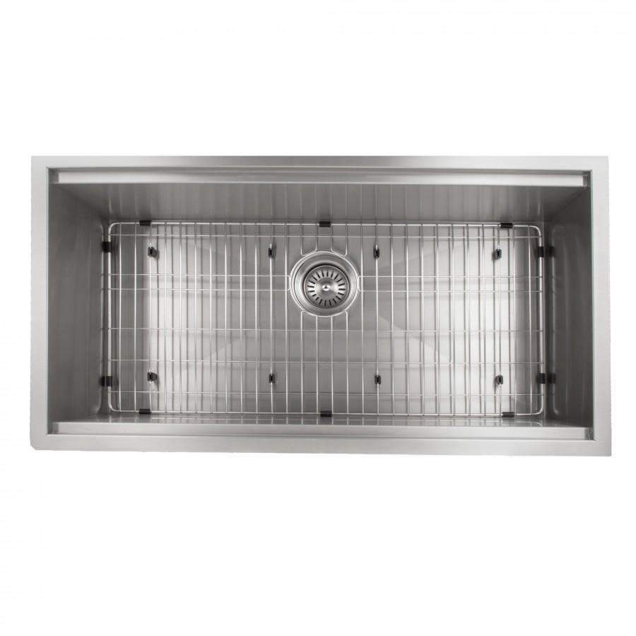 Undermount stainless steel sink basin with bottom grid and round drain strainer.