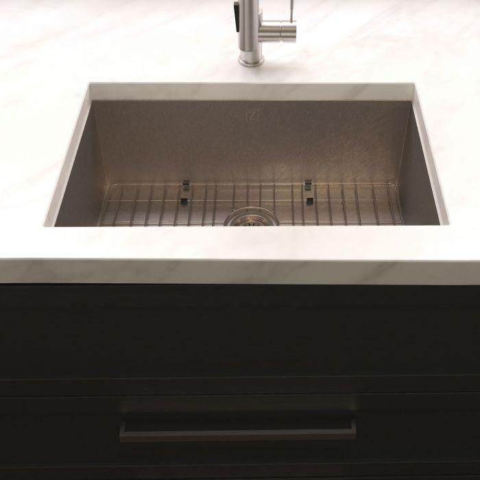 Stainless steel single-bowl undermount sink with central drain strainer on countertop