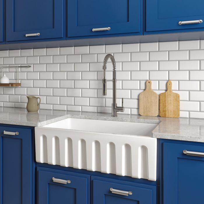 White apron-front single-bowl kitchen sink with ribbed front skirt