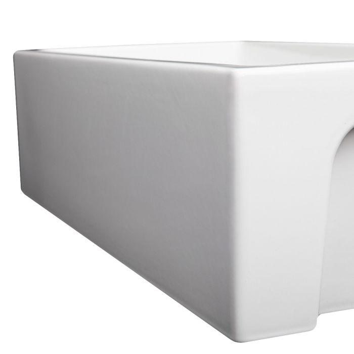 White glossy apron-front single-bowl fireclay sink, close-up corner view