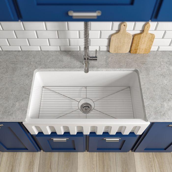 White apron-front single-bowl sink with bottom rack visible
