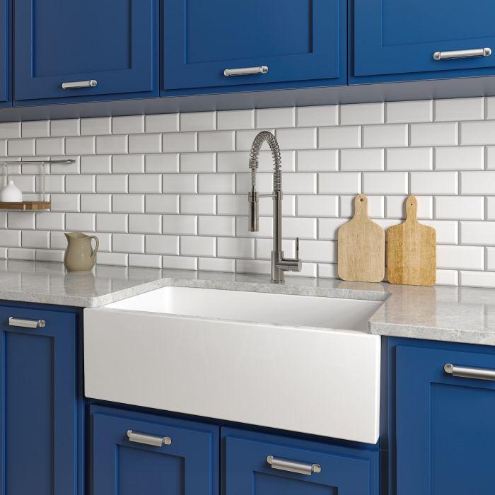 White apron-front single-bowl sink with faucet and bottom grid installed