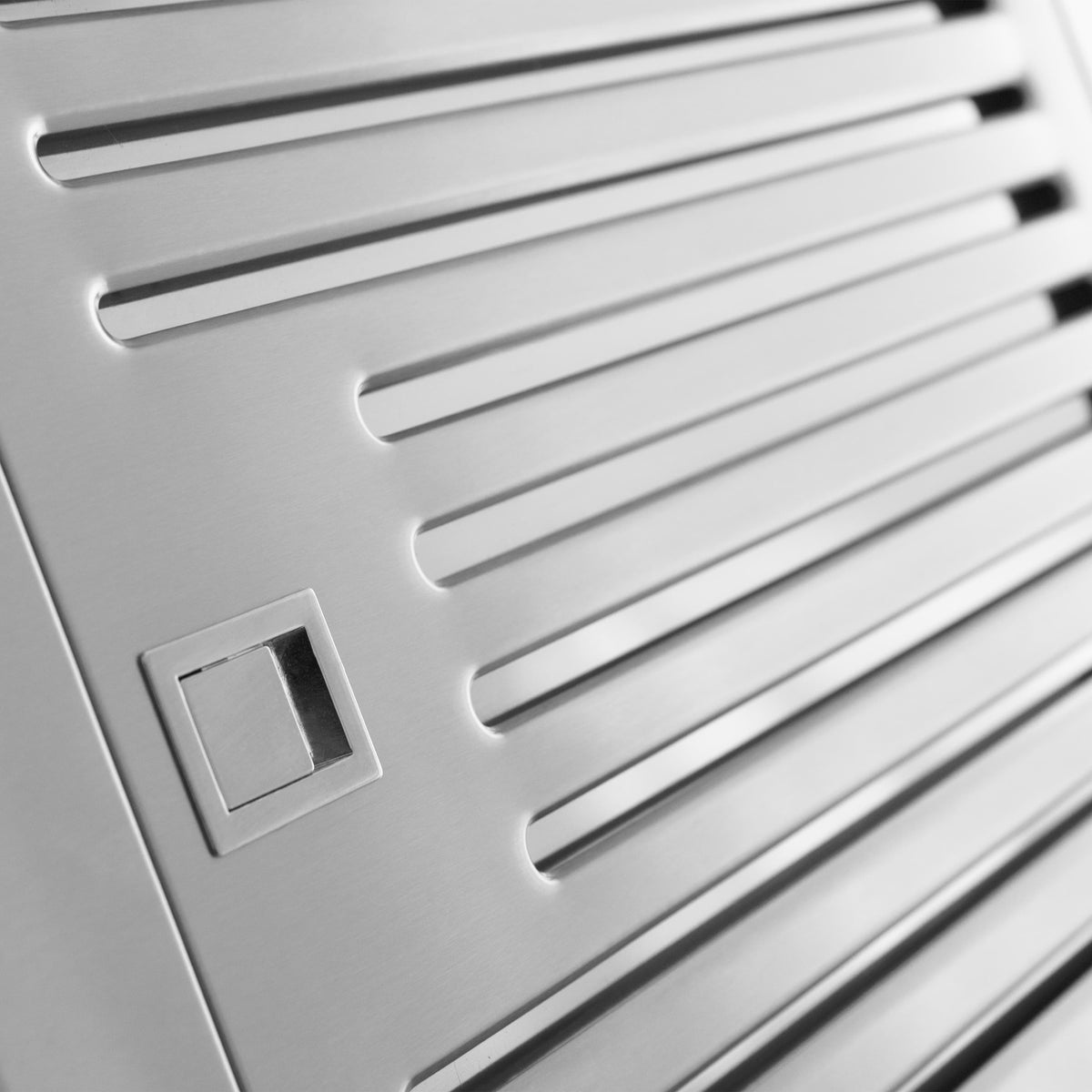 Stainless range hood vent grilles and control square near panel edge