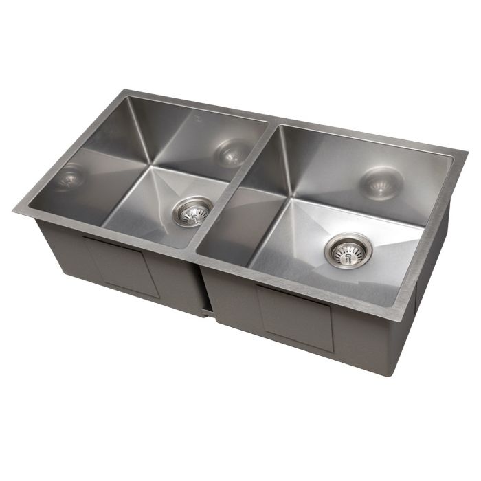 Stainless steel double-bowl sink shown at angle with two drain openings