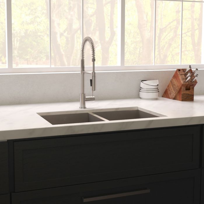 Undermount stainless steel double-bowl sink installed in countertop with faucet