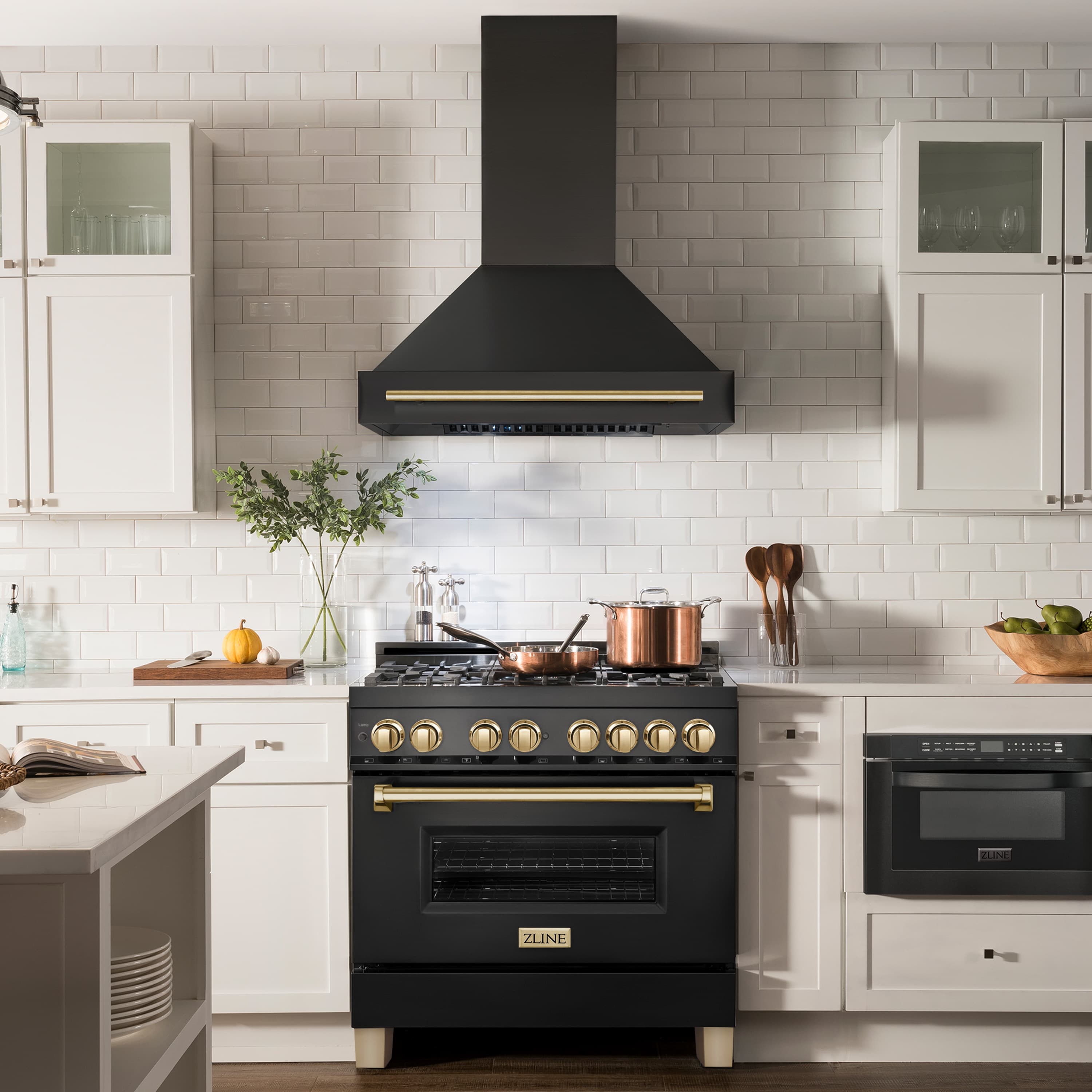 Black wall-mount range hood with gold bar trim above stove burners