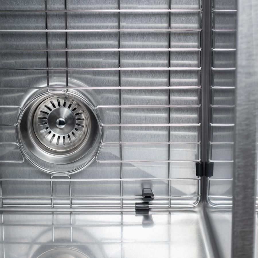 Close-up of stainless steel sink drain strainer and wire grid in one basin